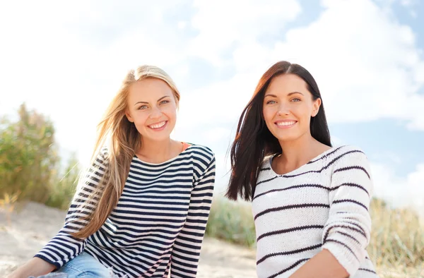 Счастливые девочки-подростки или молодые женщины на пляже — стоковое фото