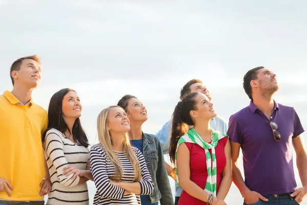 Grupo de amigos felizes olhando para cima na praia — Fotografia de Stock