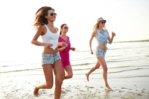 Grupo de mulheres sorridentes correndo na praia — Fotografia de Stock