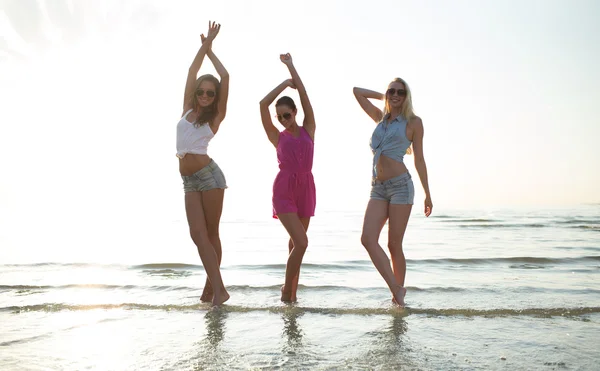 Happy female friends dancing on beach — Stock Photo, Image