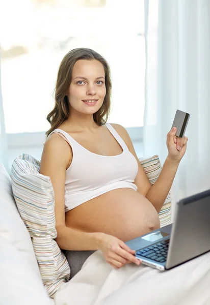 Mujer embarazada con portátil y tarjeta de crédito en casa —  Fotos de Stock