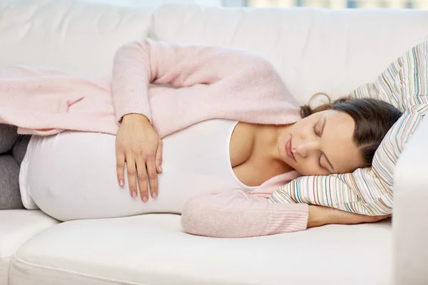 Glad gravid kvinna som sover på soffan hemma — Stockfoto