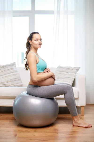 Mulher grávida feliz exercitando em fitball em casa — Fotografia de Stock