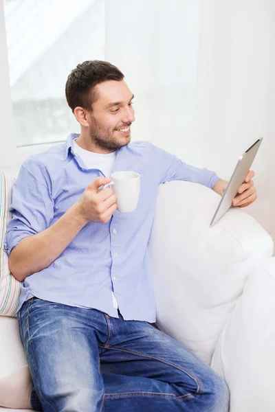 Uśmiechnięty mężczyzna z komputera typu tablet i Puchar w domu — Zdjęcie stockowe