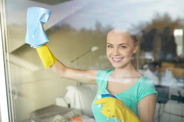 Mujer feliz en guantes ventana de limpieza con trapo —  Fotos de Stock