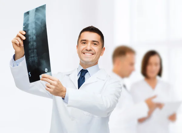 Sonriente médico masculino sosteniendo rayos X en el hospital — Foto de Stock