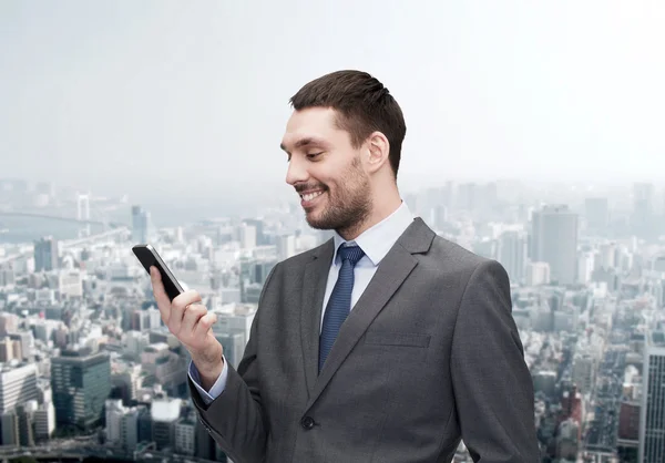 Молодой улыбающийся бизнесмен со смартфоном — стоковое фото