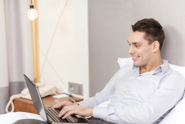 Glückliche Geschäftsfrau mit Laptop im Hotelzimmer — Stockfoto