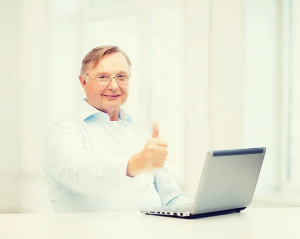 Oude man met laptopcomputer duimen opdagen — Stockfoto