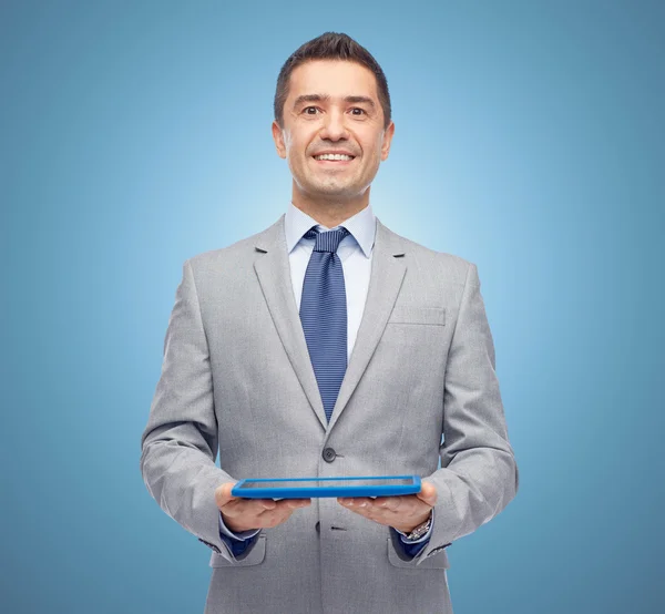 Homem de negócios feliz em terno segurando tablet pc — Fotografia de Stock