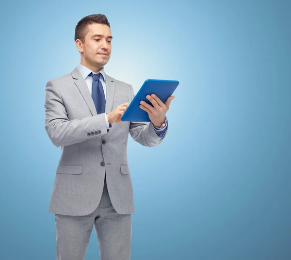 Šťastný podnikatel v obleku držení počítače tablet pc — Stock fotografie
