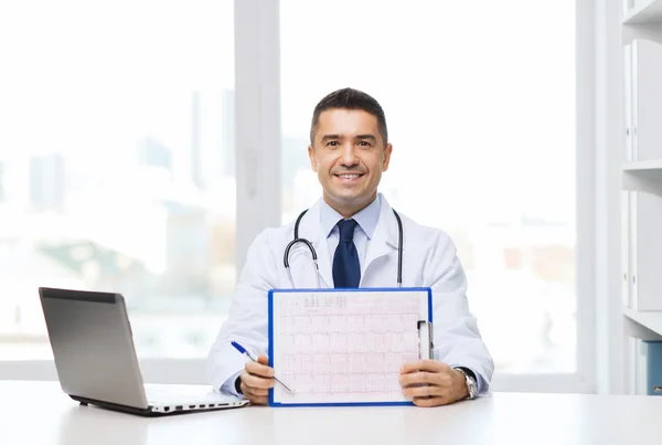 Médico feliz con portapapeles y portátil en la oficina —  Fotos de Stock