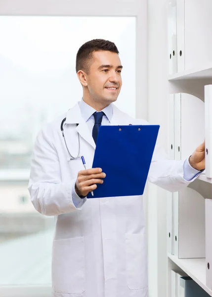 Счастливый доктор с планшетом в медицинском кабинете — стоковое фото