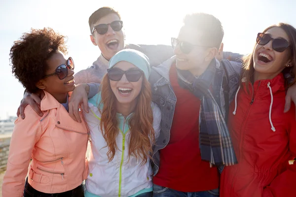 Amis souriants dans des lunettes de soleil riant dans la rue — Photo