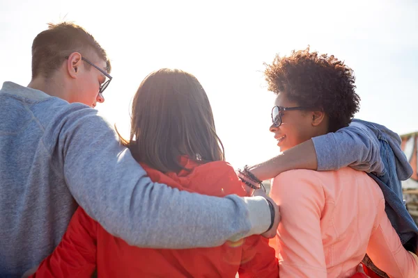 Gelukkig jeugdvrienden in tinten knuffelen op straat — Stockfoto