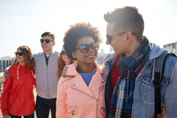 Happy teenage friends in shades talking on street — Stock Photo, Image