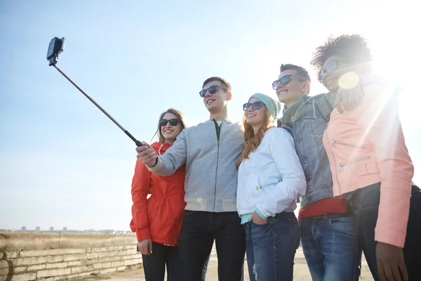 Amigos sonrientes tomando selfie con teléfono inteligente —  Fotos de Stock