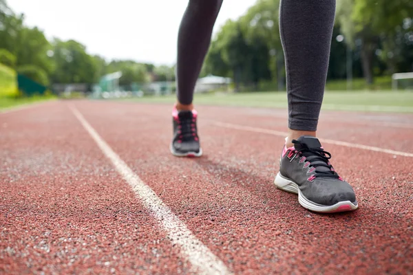 Primer plano de los pies de la mujer corriendo por la pista desde atrás — Foto de Stock