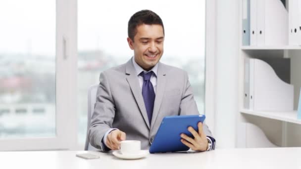 Uomo d'affari sorridente con tablet pc bere caffè — Video Stock