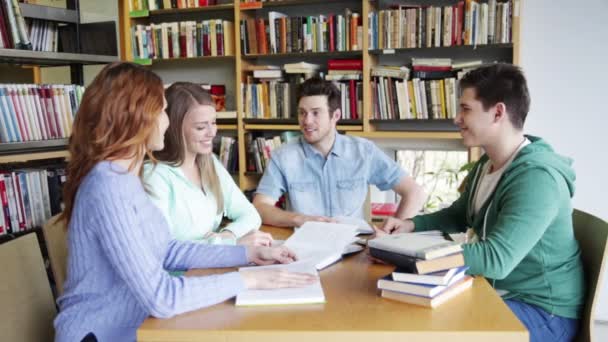 Φοιτητές με βιβλία που προετοιμάζονται για εξετάσεις στη βιβλιοθήκη — Αρχείο Βίντεο