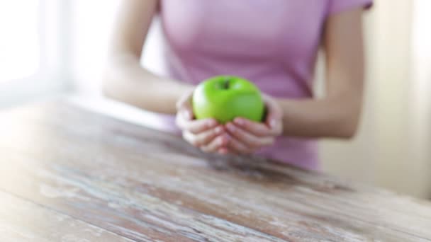 Крупным планом руки молодой женщины, показывающей зеленое яблоко — стоковое видео