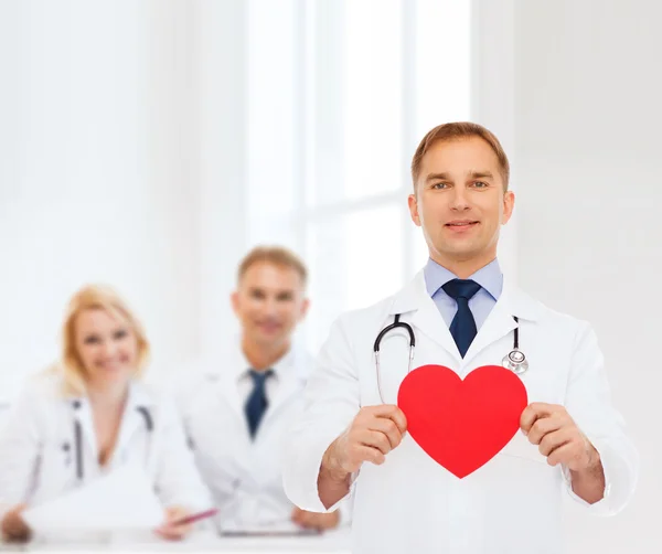 Médecin masculin souriant avec coeur rouge et stéthoscope — Photo