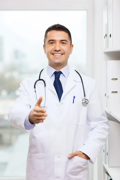 Улыбающийся доктор пожимает руку в медицинском кабинете — стоковое фото