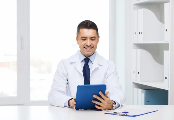 Улыбающийся мужчина врач в белом халате с планшетным ПК — стоковое фото