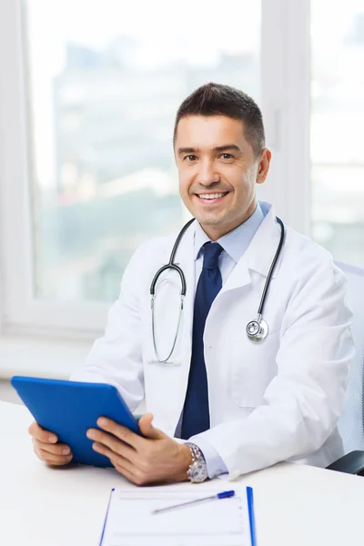 Tablet pc ile beyaz montlu erkek doktor gülümseyen — Stok fotoğraf