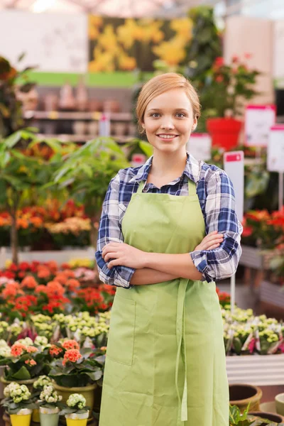 Happy woman with flowers in greenhouse — Stock Photo, Image