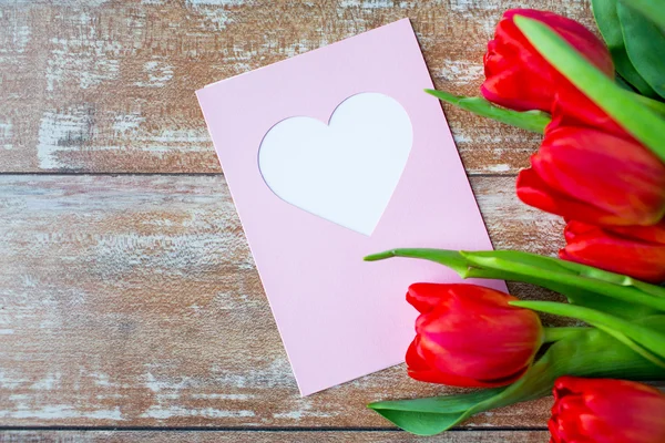 Närbild på tulpaner och gratulationskort med hjärta — Stockfoto