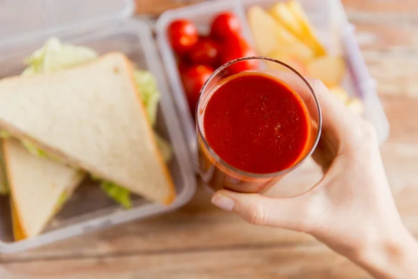 Primo piano della mano della donna che tiene il bicchiere di succo di pomodoro — Foto Stock