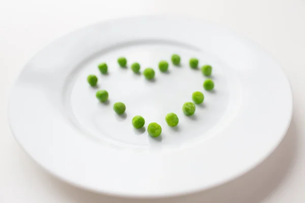 Primer plano de la placa con guisantes en forma de corazón —  Fotos de Stock