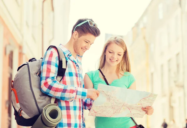 Coppia sorridente con mappa e zaino in città — Foto Stock