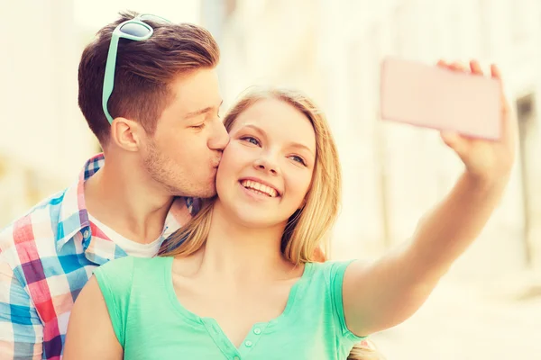 Lachende paar met smartphone in stad — Stockfoto