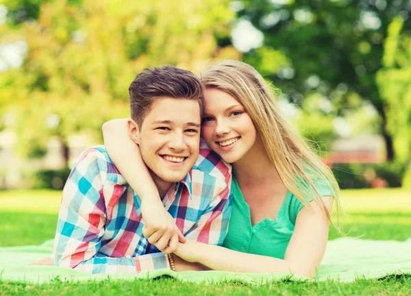 Uśmiechający się para leży na kocu w parku — Zdjęcie stockowe