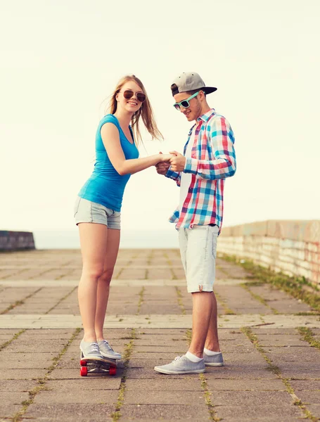 Usmívající se pár s skateboard venku — Stock fotografie