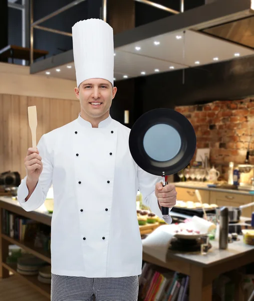 Happy male chef holding frying pan and spatula — Stock Photo, Image