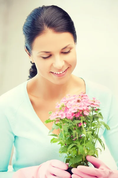 Härliga hemmafru med blomma i kruka — Stockfoto