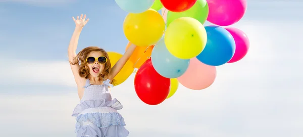 Happy jumping girl with colorful balloons — Stock Photo, Image