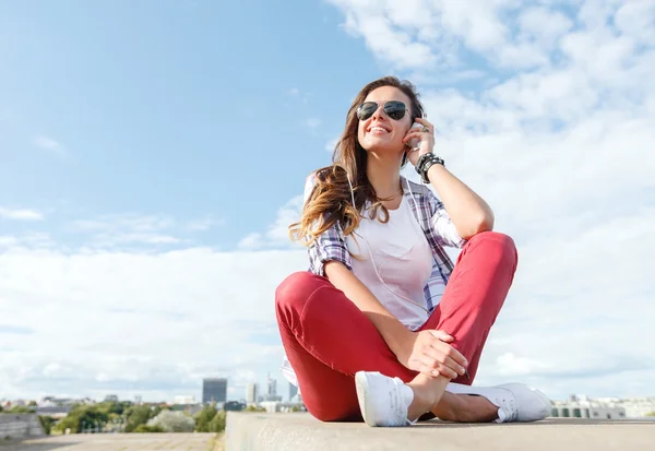 Lachende tienermeisje in bril met koptelefoon — Stockfoto