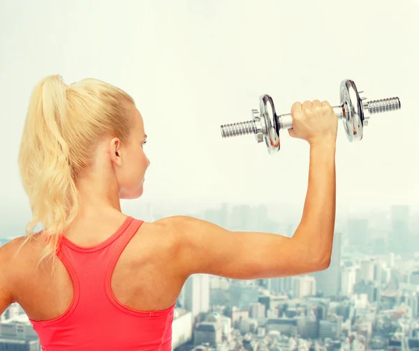 Sportieve vrouw met zware stalen dumbbell van terug — Stockfoto