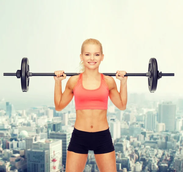 Smiling sporty woman exercising with barbell — Stock Photo, Image