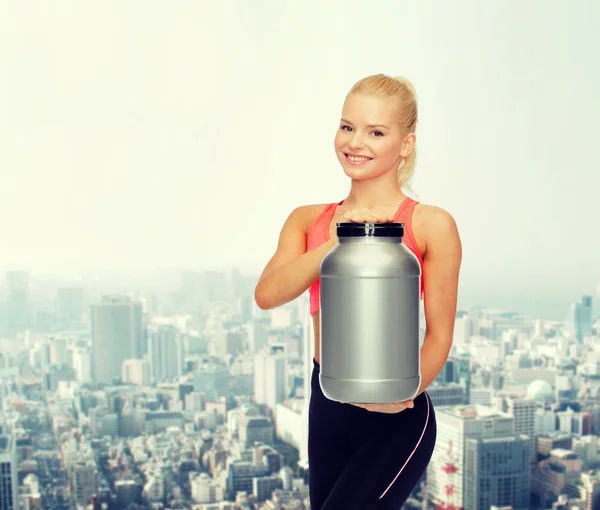 Mujer deportiva sonriente con tarro de proteína — Foto de Stock