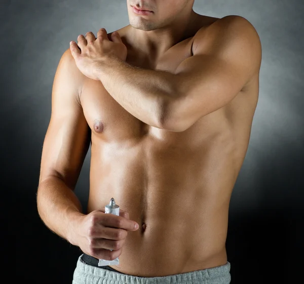 Young male bodybuilder applying pain relief gel — Stock Photo, Image