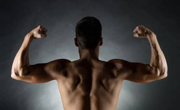 Young man showing biceps — Stock Photo, Image