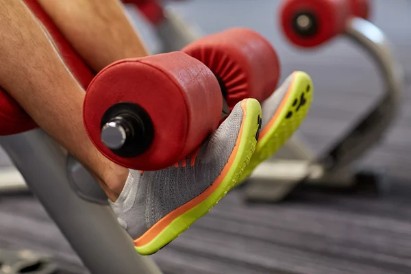 Close-up de homem pernas exercitando na máquina de ginásio — Fotografia de Stock