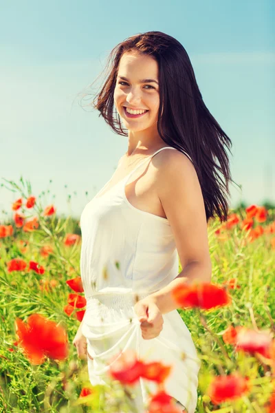 Sorrindo jovem mulher no campo de papoula — Fotografia de Stock