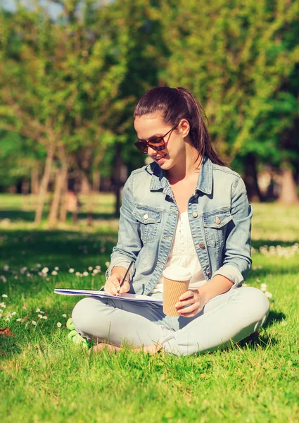 Sorrindo menina com notebook e xícara de café — Fotografia de Stock