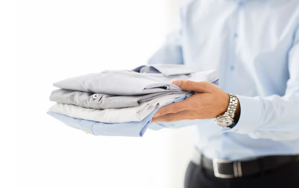 Close up of businessman holding folded shirts — Stock Photo, Image